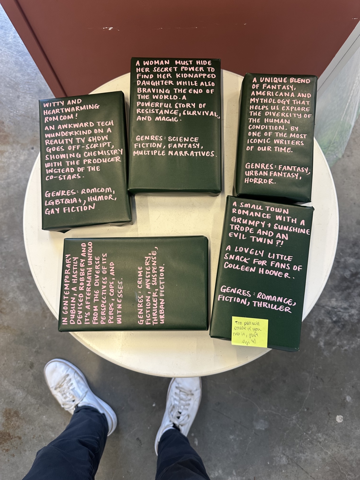 A table covered in books, each gift
      wrapped and with a description written on the outside.